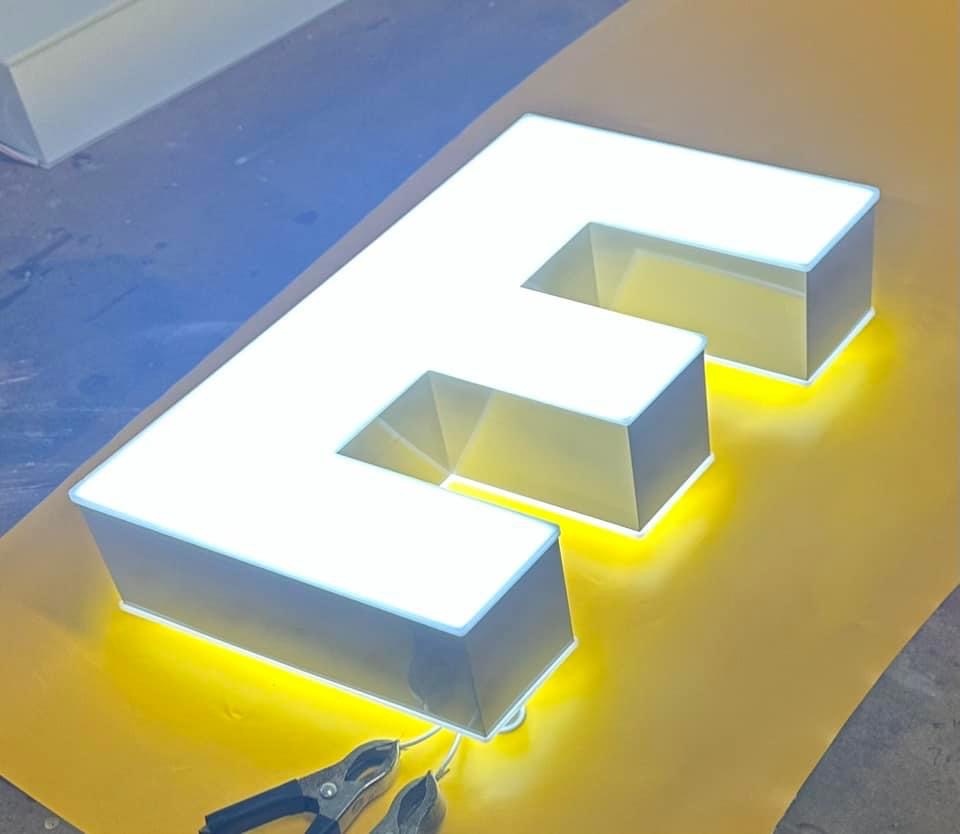 Illuminated 3D letter with LED lighting on a workbench