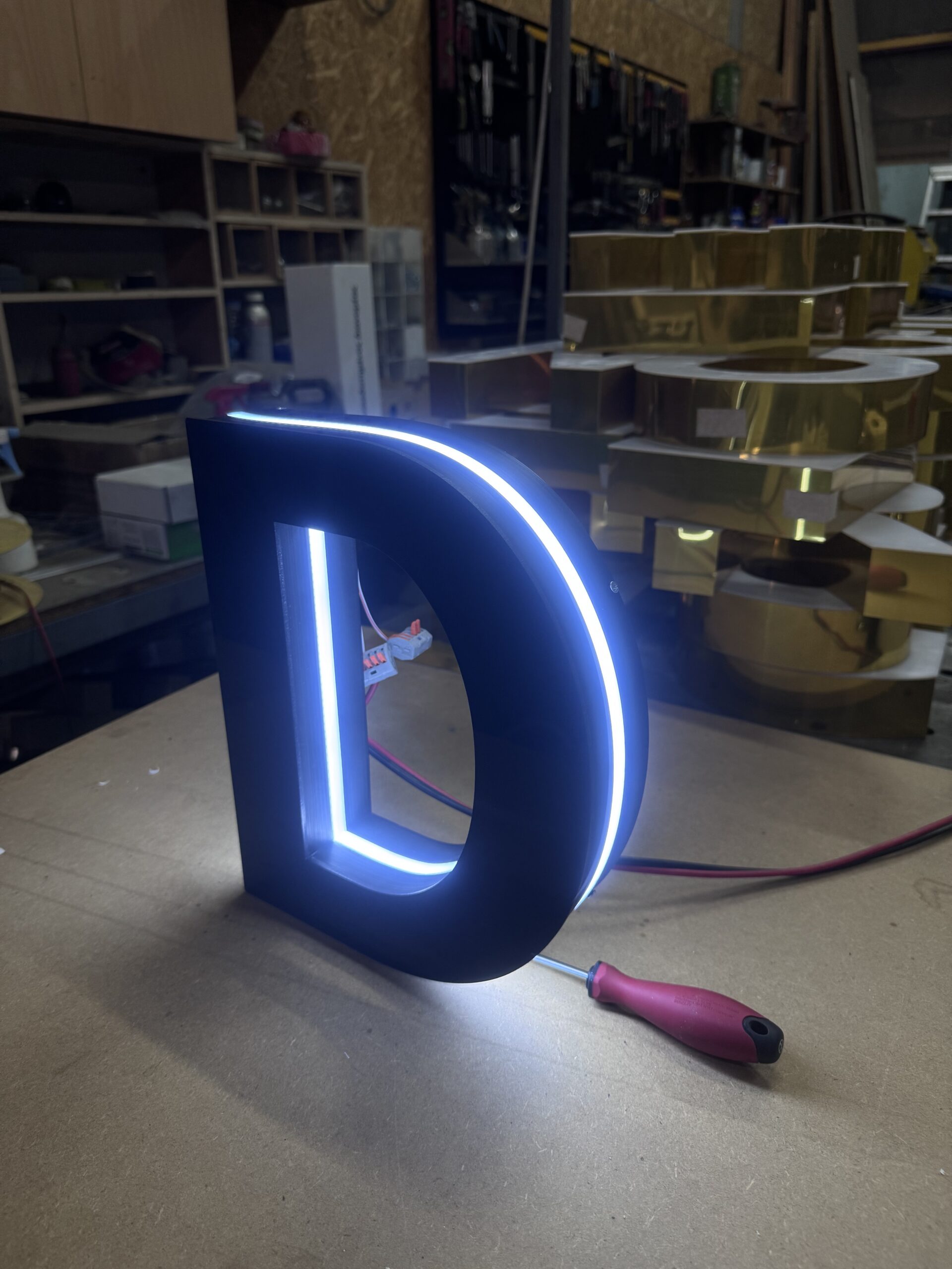 LED illuminated 3D letter 'D' on workbench