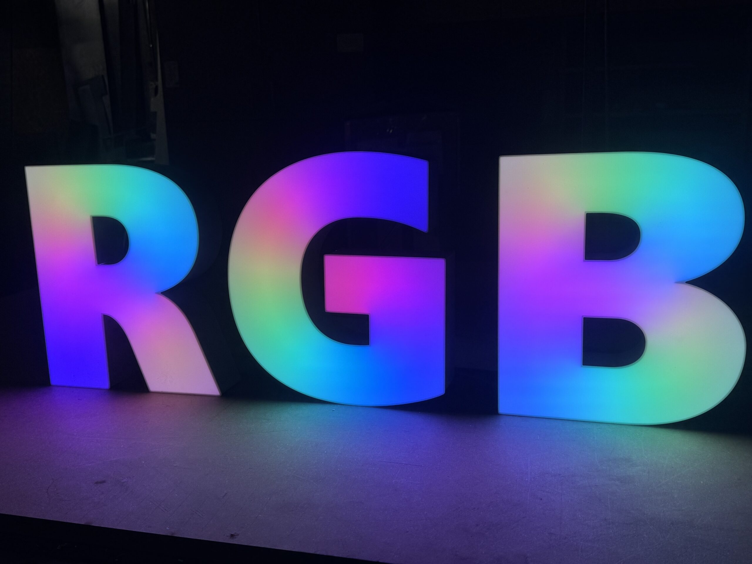Illuminated RGB 3D letters displaying multi-colored lighting effects