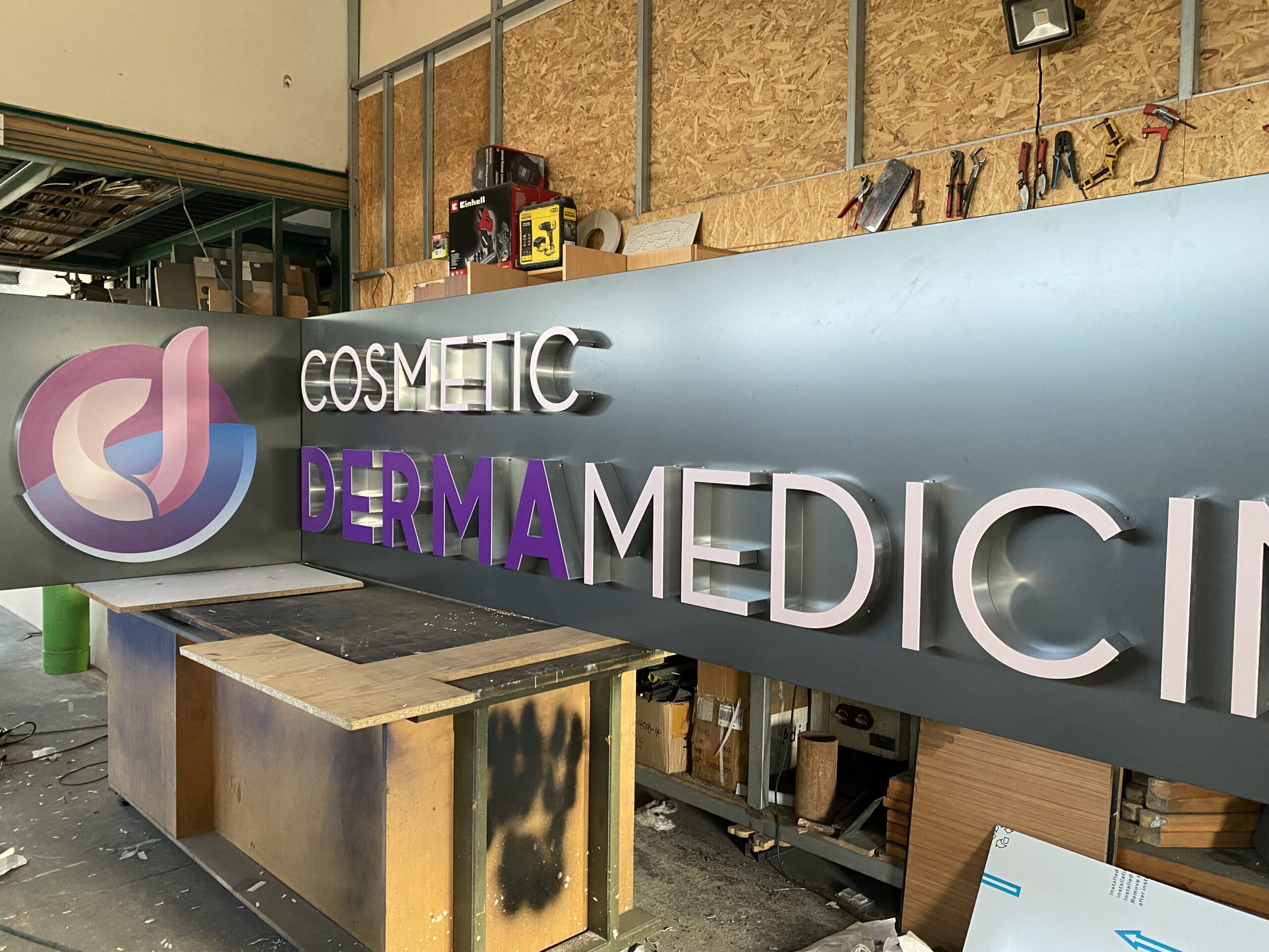 3D lit signage for 'Cosmetic Derma Medicine' in a workshop