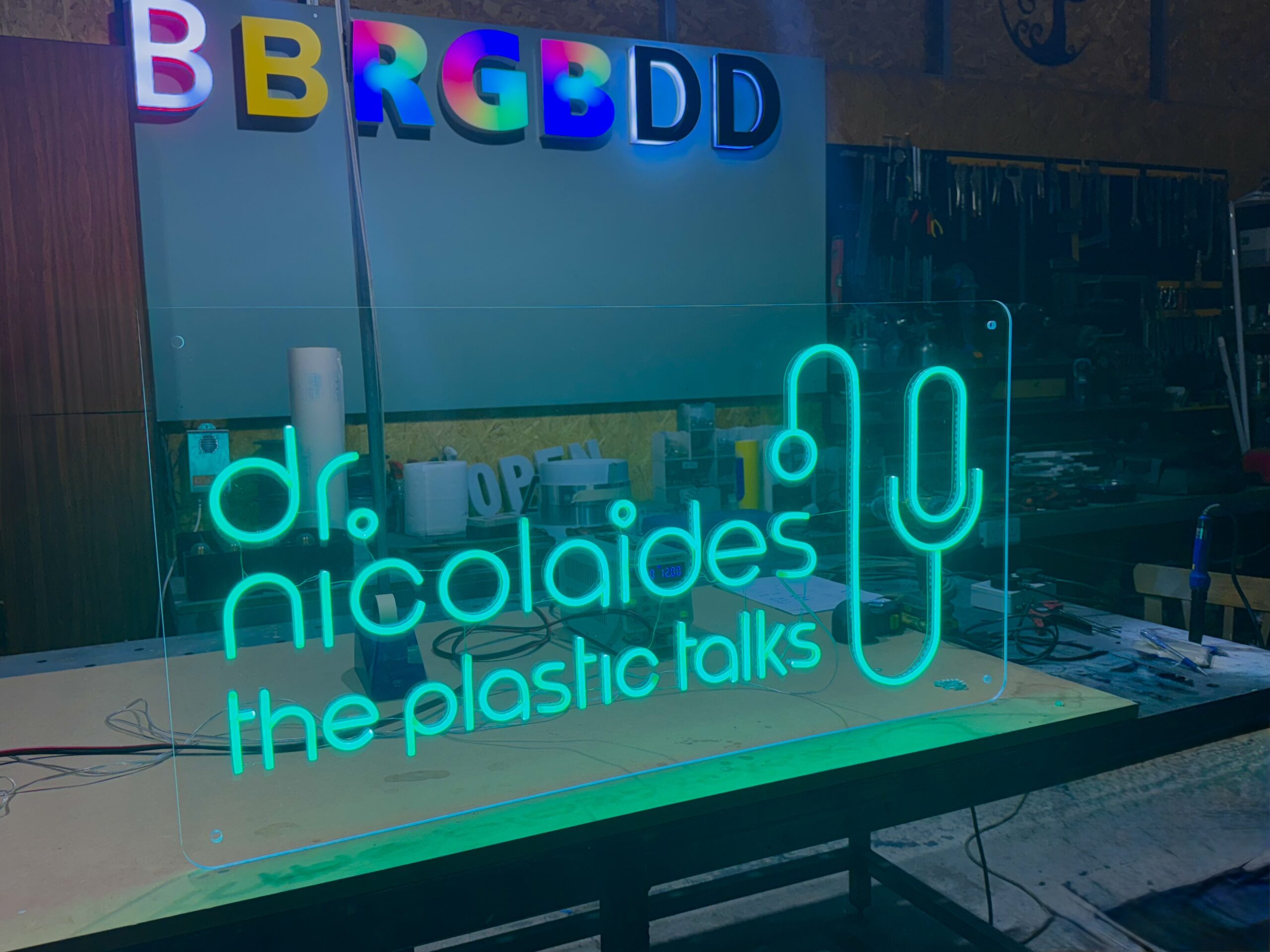 Green neon sign on clear plexiglass with custom design in Limassol workshop.
