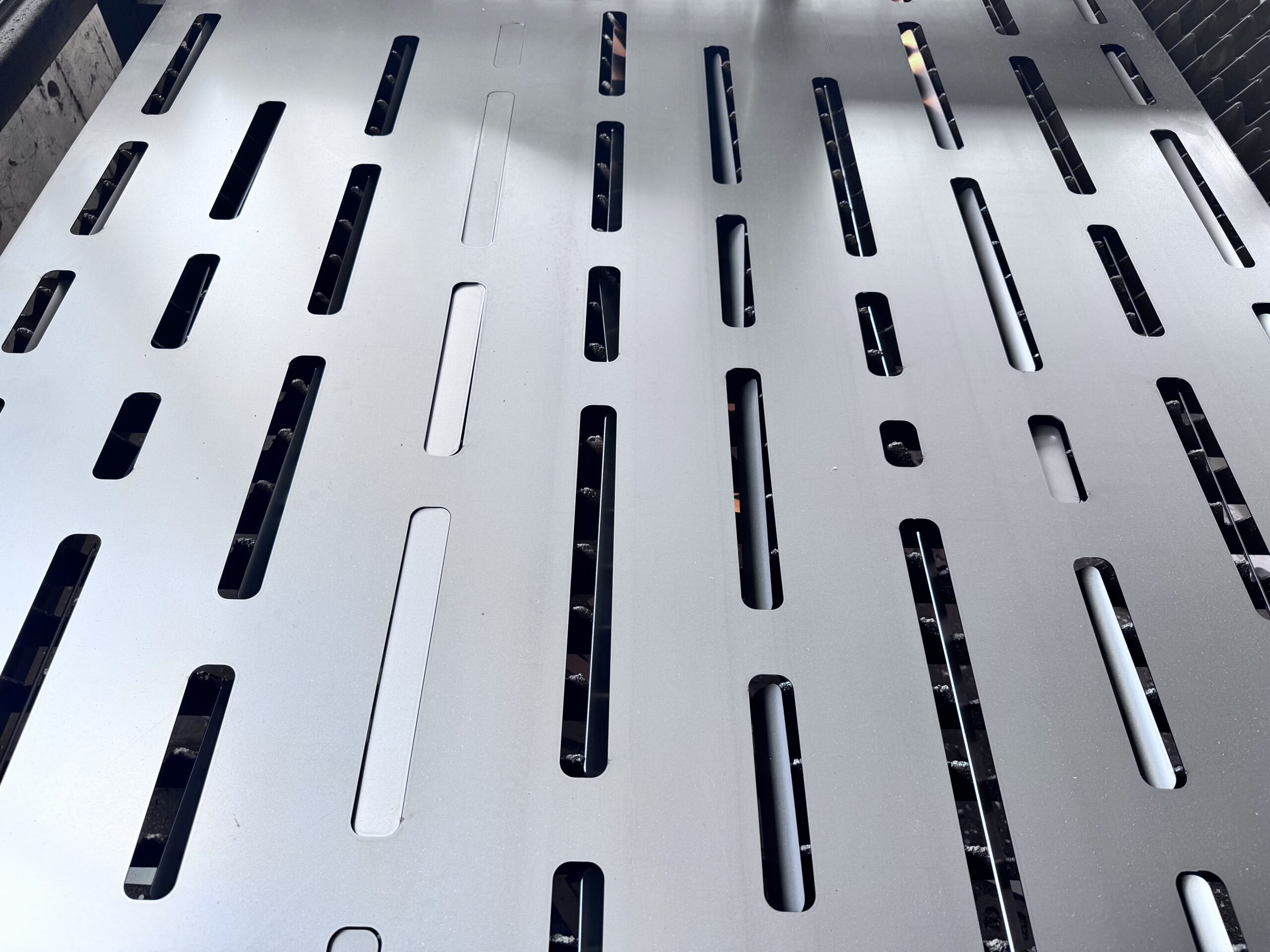 Precision laser-cut steel panels with elongated slots for gate construction