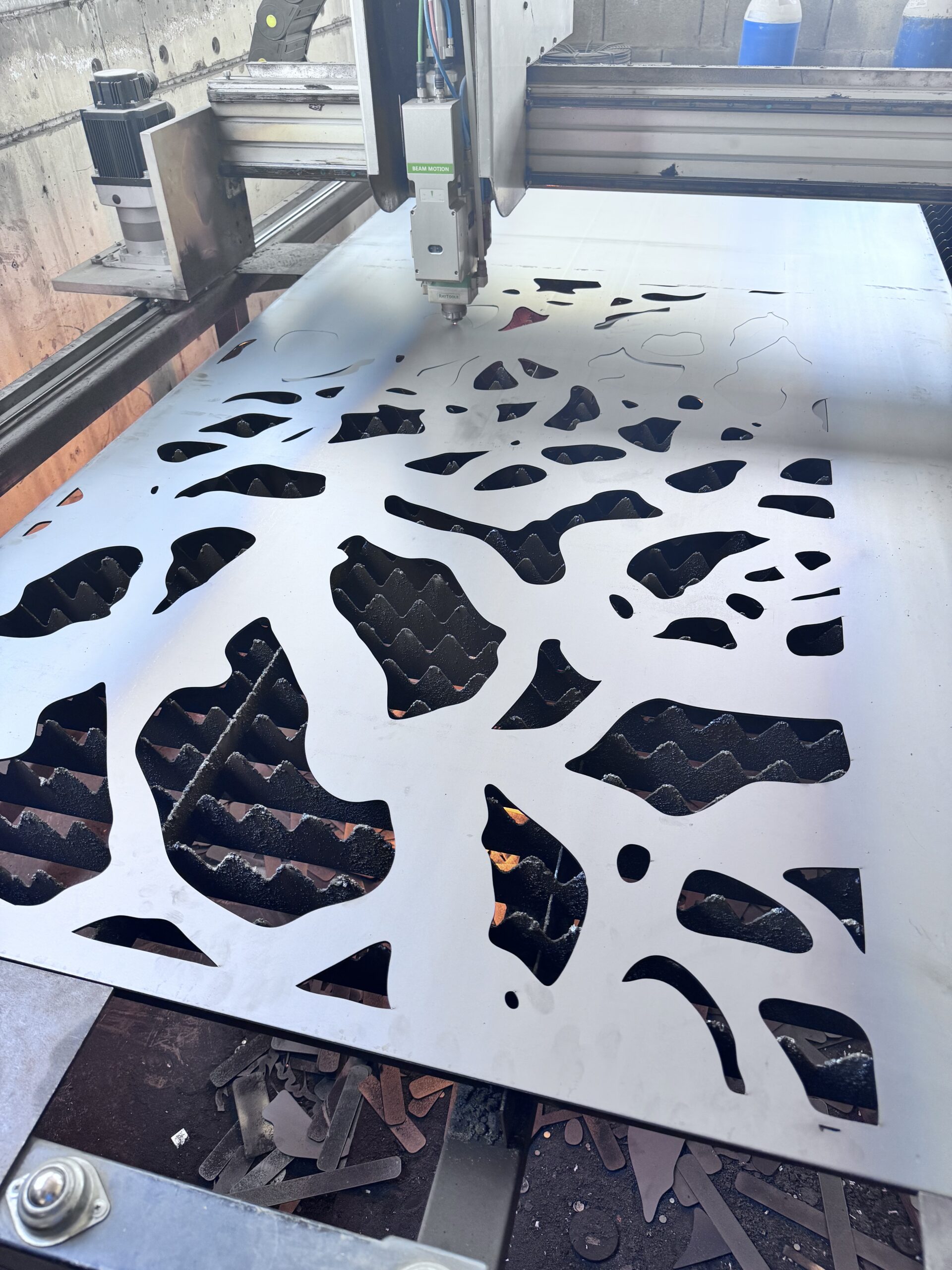 Fiber laser cutting 3mm steel panel with custom design.