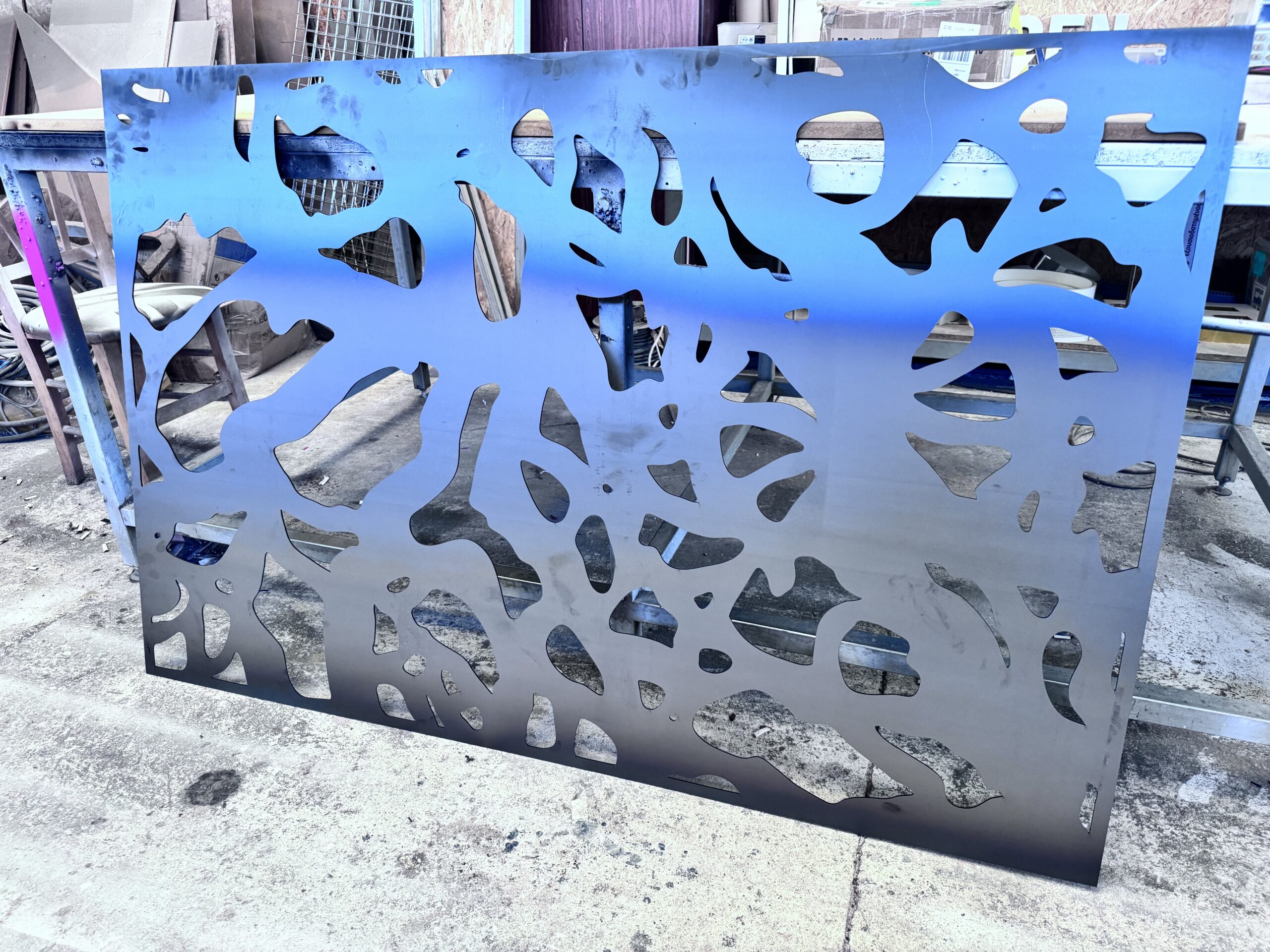 Laser cut steel panel with abstract design pattern.