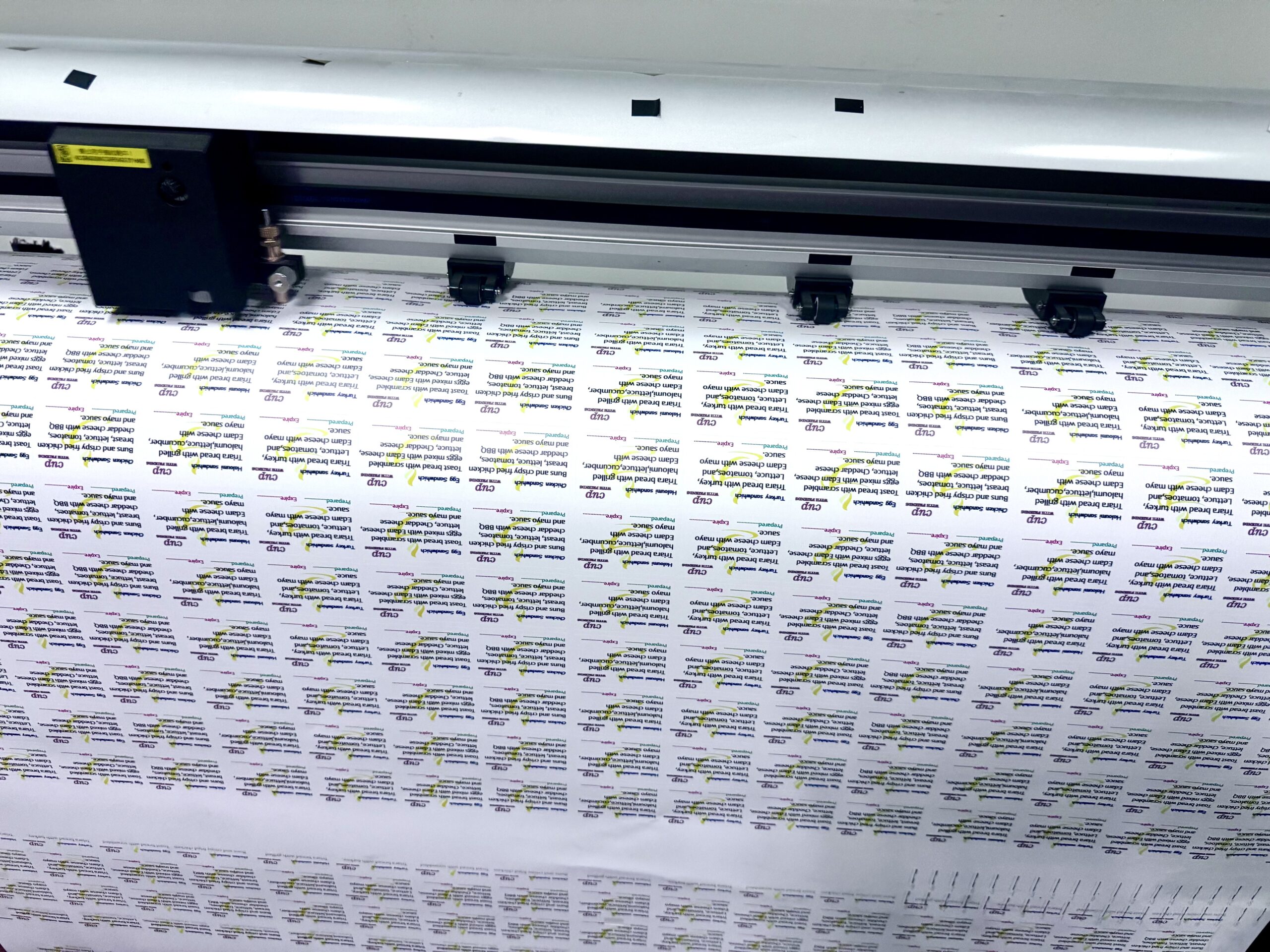Printing machine creating sandwich ingredient stickers in Nicosia.