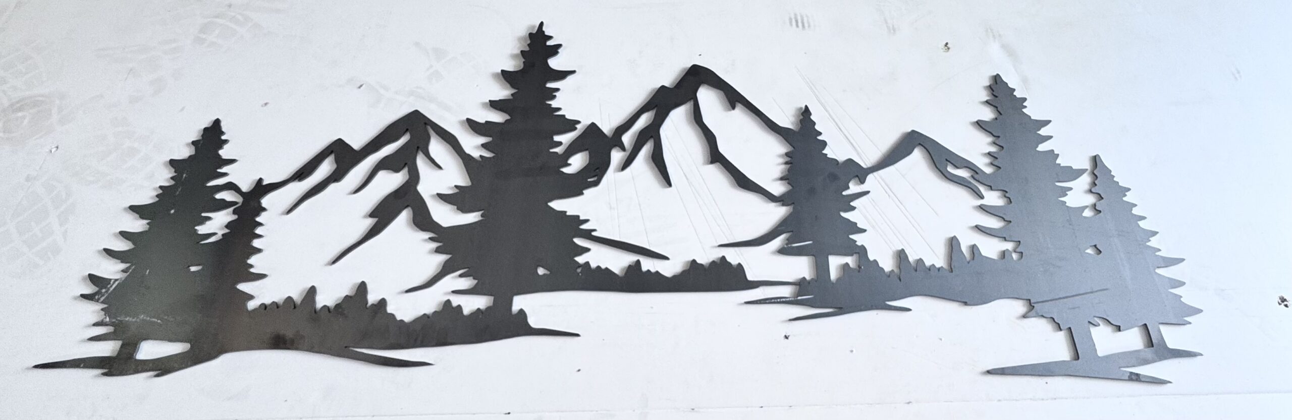 Mountain and forest metal art piece on display