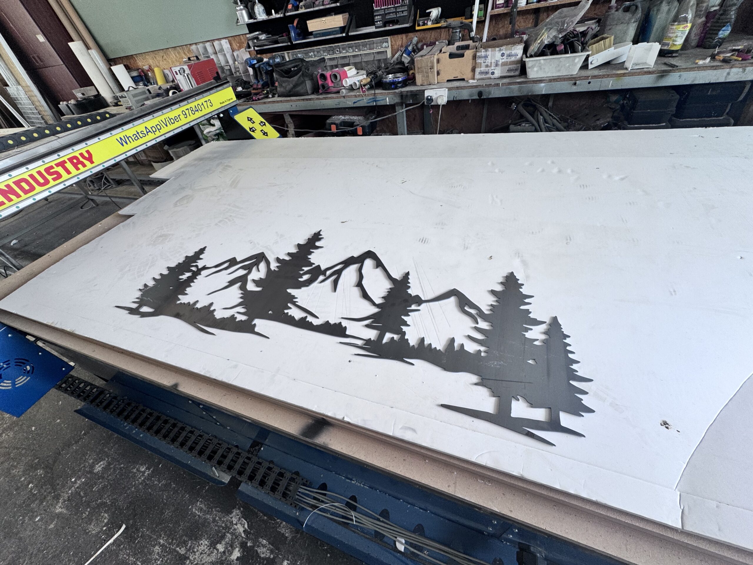 Carbon steel mountain landscape metal art piece in workshop.