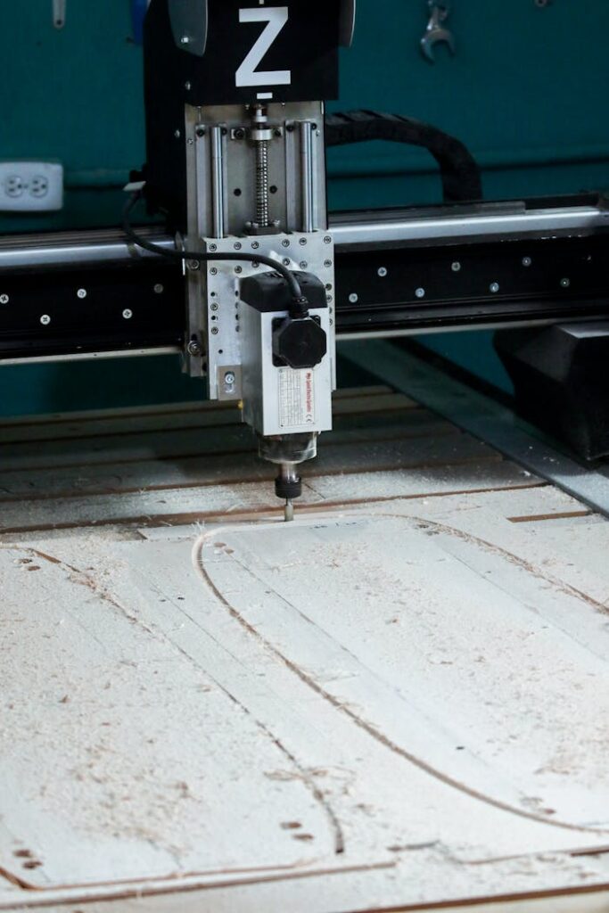 pexels-photo-10119311 Close-up of a CNC milling machine operating in a workshop setting, cutting patterns into wood.