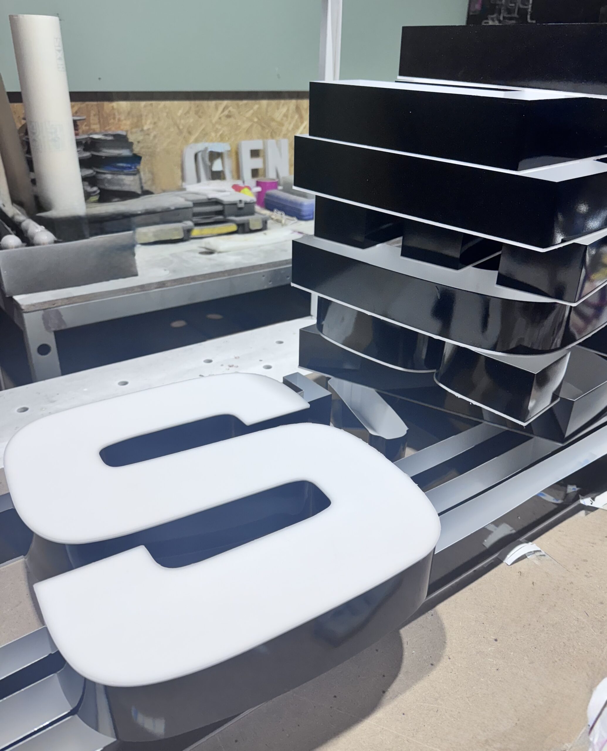 3D letters with black aluminum sides and white faces.
